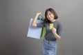 Portrait of young beautiful asian woman holding credit card and colorful shopping bag isolated over gray background studio Royalty Free Stock Photo