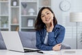 Portrait of young beautiful asian woman at home, woman smiling and looking at camera, working remotely in home office Royalty Free Stock Photo