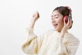 Portrait of young beautiful Asian woman listening to music through wireless headphones with fun happiness, isolate with white Royalty Free Stock Photo