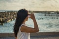 Portrait of a young beautiful asian woman looking at ocean on the city beach during sunset time Royalty Free Stock Photo