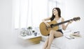 Portrait of young beautiful asian woman playing guitar music, sing and dance in bedroom. Royalty Free Stock Photo