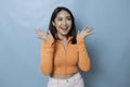 Portrait of Young beautiful Asian woman standing and smiling at the camera,  on blue background Royalty Free Stock Photo