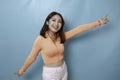 Portrait of Young beautiful Asian woman standing and smiling at the camera, isolated on blue background Royalty Free Stock Photo