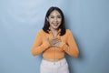 Portrait of Young beautiful Asian woman standing and smiling at the camera, isolated on blue background Royalty Free Stock Photo