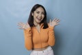 Portrait of Young beautiful Asian woman standing and smiling at the camera, isolated on blue background Royalty Free Stock Photo