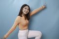 Portrait of Young beautiful Asian woman standing and smiling at the camera, isolated on blue background Royalty Free Stock Photo