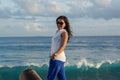 Portrait of a young beautiful asian woman in sunglasses on the city beach during sunset time looking back Royalty Free Stock Photo