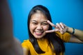 Portrait of Young beautiful asian women wearing yellow shirt with blue  background Royalty Free Stock Photo