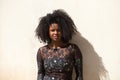 Portrait of a young, beautiful black woman with afro hair and a black dress with flowers with a sad and serious expression. In the Royalty Free Stock Photo