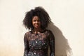 Portrait of a young, beautiful black woman with afro hair and a black dress with flowers with a sad and serious expression. In the Royalty Free Stock Photo