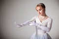 Portrait of young beautiful blond ballerina woman in white tutu, gloves and jewelry Royalty Free Stock Photo