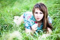 Portrait of young beautiful blond woman lying in grass and flowers on summer day with green nature landscape Royalty Free Stock Photo