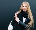 Portrait of a young beautiful blonde girl nex to black background. Spring, young, beauty. Outdoor. Warm color.