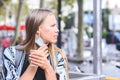 Portrait of a young beautiful blonde model removing mask to drink a take away coffee in the street Royalty Free Stock Photo