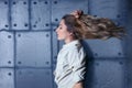 Portrait of young beautiful blonde woman with flying hair on metal wall background Royalty Free Stock Photo