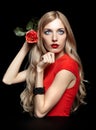 Portrait of young beautiful blonde woman in red dress with red r Royalty Free Stock Photo