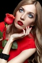 Portrait of young beautiful blonde woman in red dress with red r Royalty Free Stock Photo