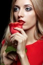 Portrait of young beautiful blonde woman in red dress with red r Royalty Free Stock Photo