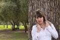 Portrait of young, beautiful, blonde woman in white shirt clutching the lapels of her shirt with seductive look and leaning on the Royalty Free Stock Photo