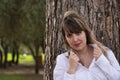 Portrait of young, beautiful, blonde woman in white shirt clutching the lapels of her shirt with seductive look and leaning on the Royalty Free Stock Photo