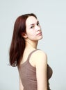 Portrait of a young beautiful brunette in a shirt, light background