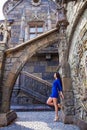 Portrait young beautiful brunette woman in blue dress posing against the backdrop of an old castle in the Gothic style Royalty Free Stock Photo