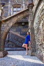 Portrait young beautiful brunette woman in blue dress posing against the backdrop of an old castle in the Gothic style Royalty Free Stock Photo