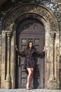 Portrait young beautiful brunette woman in dress posing against the backdrop of an old castle in the Gothic style Royalty Free Stock Photo