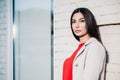 Portrait young beautiful brunette woman standing near white brick wall outdoors in urban background Royalty Free Stock Photo