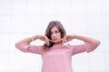 Portrait of a young beautiful brunette woman on the street, female urban street fashion, lines of buildings