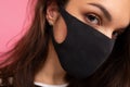 Portrait of young beautiful brunette woman wearing mediacal face mask over background wall. Protection against