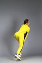 Portrait of a young beautiful brunette woman in yellow tracksuit Royalty Free Stock Photo