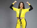 Portrait of a young beautiful brunette woman in yellow tracksuit Royalty Free Stock Photo