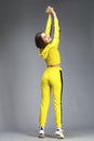 Portrait of a young beautiful brunette woman in yellow tracksuit Royalty Free Stock Photo