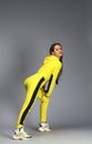 Portrait of a young beautiful brunette woman in yellow tracksuit Royalty Free Stock Photo