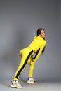 Portrait of a young beautiful brunette woman in yellow tracksuit Royalty Free Stock Photo