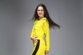 Portrait of a young beautiful brunette woman in yellow tracksuit Royalty Free Stock Photo