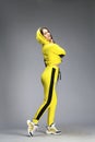 Portrait of a young beautiful brunette woman in yellow tracksuit Royalty Free Stock Photo