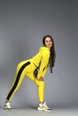 Portrait of a young beautiful brunette woman in yellow tracksuit Royalty Free Stock Photo