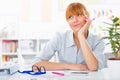 Portrait of a young beautiful businesswoman sitting her desk and thinking Royalty Free Stock Photo