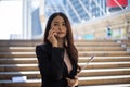 Portrait of young beautiful businesswoman standing and using mobile phone Royalty Free Stock Photo