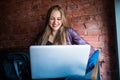 Portrait of a young beautiful businesswomen enjoying coffee during work on portable laptop computer, charming female student using Royalty Free Stock Photo