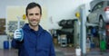 Portrait of a young beautiful car mechanic in a car workshop, in the background of service. Concept: repair of machines, fault dia Royalty Free Stock Photo