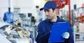 Portrait of a young beautiful car mechanic in a car workshop, in the background of service. Concept: repair of machines, fault dia Royalty Free Stock Photo