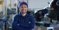 Portrait of a young beautiful car mechanic in a car workshop, in the background of service. Concept: repair of machines, fault dia Royalty Free Stock Photo