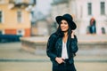 Portrait of young beautiful casual girl in jacket an black hat walking on spring city street. Royalty Free Stock Photo