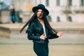 Portrait of young beautiful casual girl in jacket an black hat walking on spring city street. Royalty Free Stock Photo