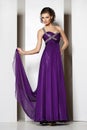Young beautiful brunette in purple dress on white Royalty Free Stock Photo