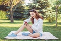 Caucasian teenage girl talking over cell mobile phone outside in park Royalty Free Stock Photo