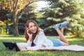 Caucasian teenage girl talking over cell mobile phone outside in park Royalty Free Stock Photo